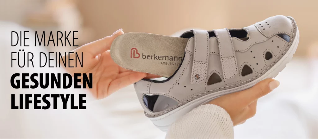 Graue Berkemann-Sandale mit Cut-Outs und herausnehmbarem Wechselfußbett, das aus dem Schuh gehoben wird.