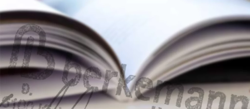 Aufgeschlagenes Buch in Nahaufnahme; die Seiten wölben sich sanft nach oben, im Vordergrund unscharf das Berkemann-Logo.