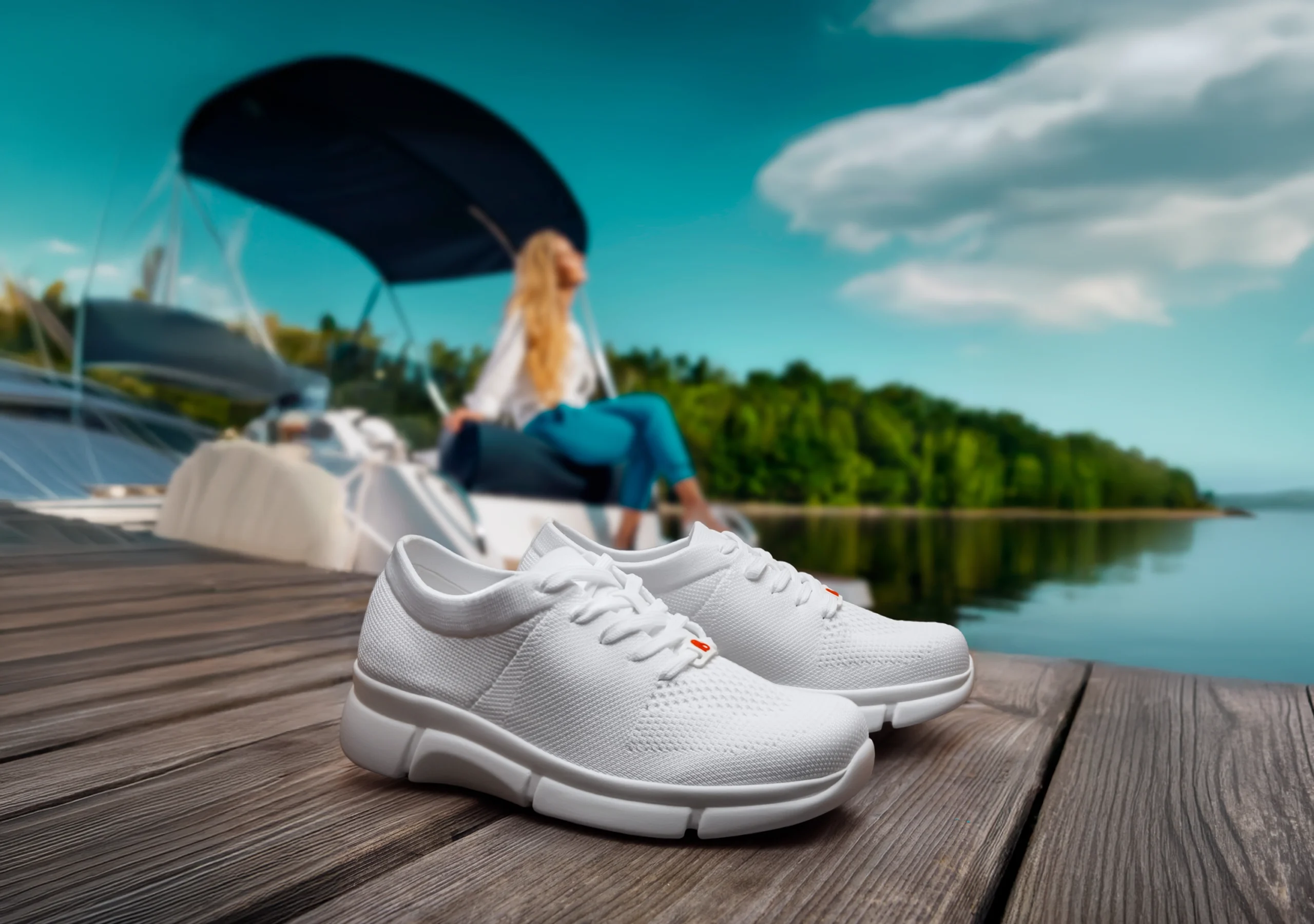 Berkemann-Model Allexis auf Bootssteg im Hintergrund Frau auf Boot, azurfarbener Himmel, sommerlich