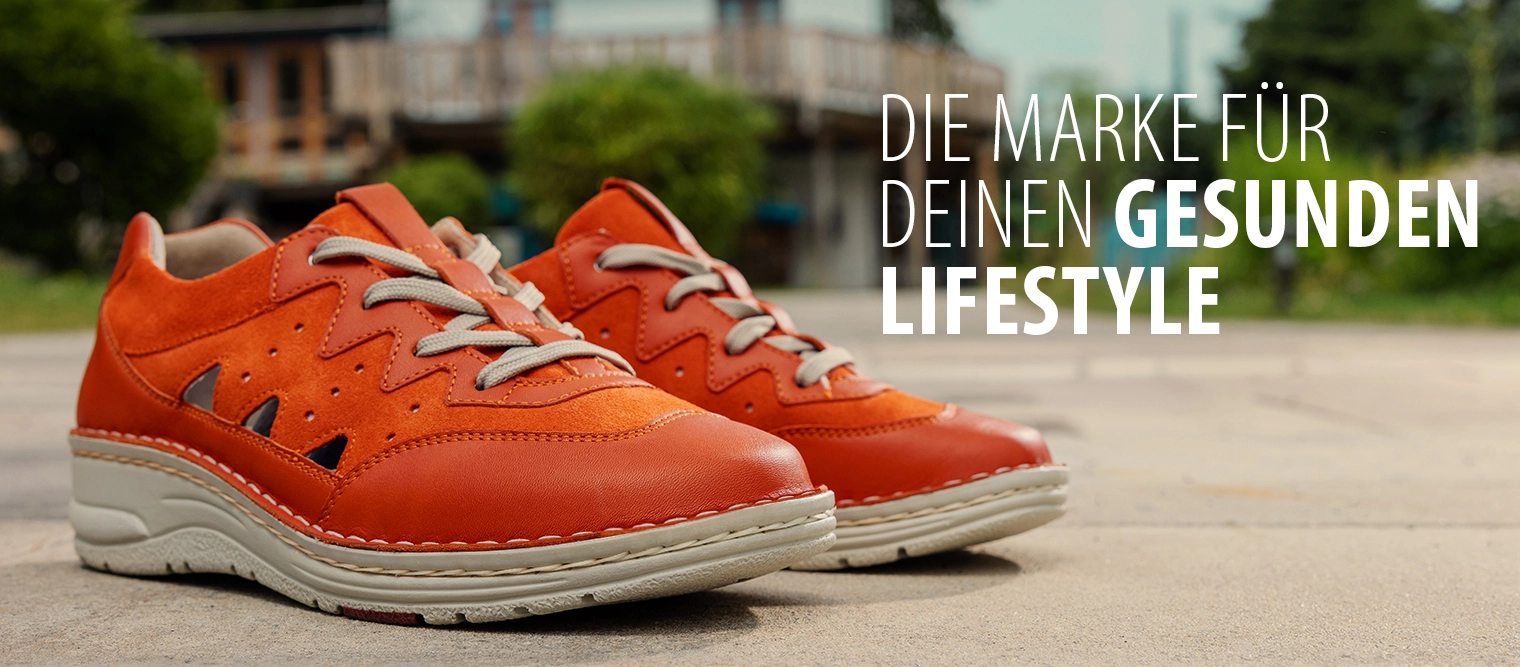 Zwei orangefarbene Schnürschuhe Laurie von Berkemann stehen im Außenbereich; rechts im Bild befindet sich der Schriftzug „Die Marke für deinen gesunden Lifestyle“.