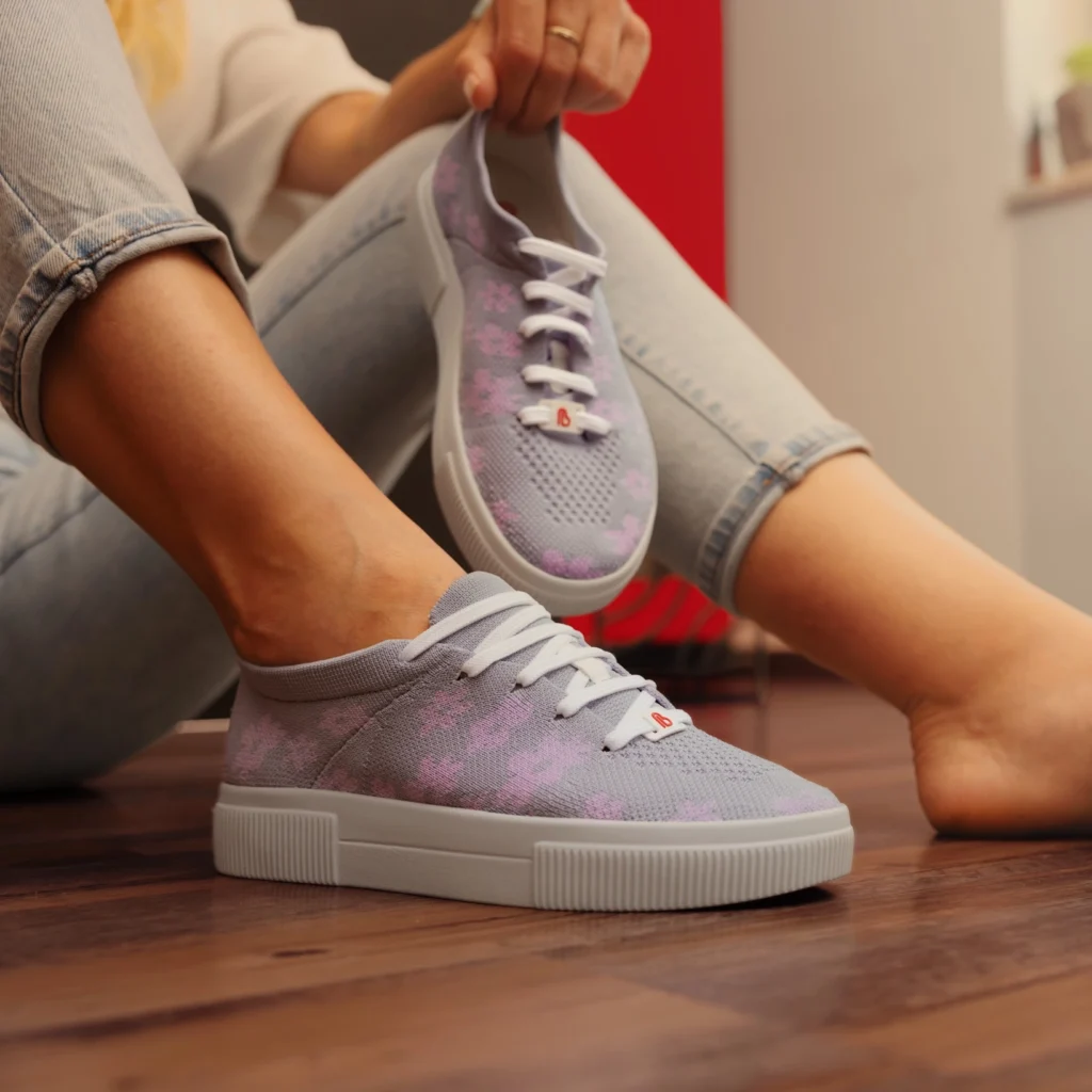 Hellviolette Komfort-Sneaker Gese von Berkemann werden von einer sitzenden Person in einem Wohnraum präsentiert.